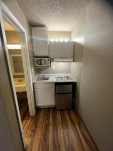 a small kitchen with white cabinets and a sink at Live In Lodge Marietta in Marietta +15 photos