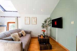 a living room with a couch and a tv at "Yunahouse" Vue sur les Salins Roses in Salin-de-Giraud