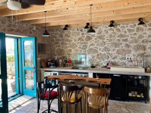 a kitchen with a table and chairs and a stone wall at Blue Dream in Murvica
