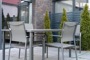 dwa krzesła i stół na patio w obiekcie Dom Black & Vibe - z ogrodem, blisko lasu, dobry design, workation - SpaceApart w Jeleniej Górze