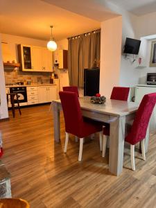 a kitchen and dining room with a table and red chairs at Casa del cuore in Barrea +4 photos