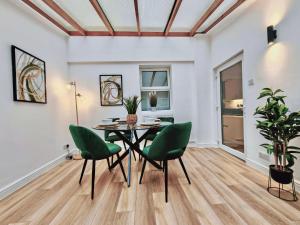 a dining room with a table and green chairs at 2-Bed Apartment - For Contractors & Business Travellers - Long Stays Welcome in Exeter