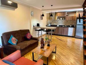 a living room with a couch and a table and a kitchen at Arasy in Puerto Iguazú