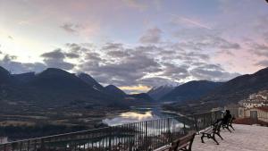 a person walking a dog on a balcony overlooking a river at Casa del cuore in Barrea