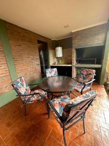 a dining room with a table and chairs and a kitchen at Arasy in Puerto Iguazú