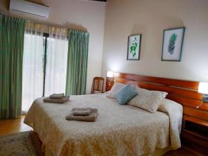 a bedroom with a large bed with two towels on it at Arasy in Puerto Iguazú +40 photos