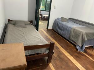 1 Schlafzimmer mit 2 Betten und Holzboden in der Unterkunft Casa rural familiar con pileta elrejunte in Arrecifes + 68 Fotos