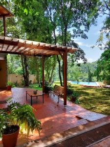 a wooden pergola with a bench on a patio at Arasy in Puerto Iguazú