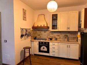 a kitchen with white cabinets and a stove top oven at Casa del cuore in Barrea