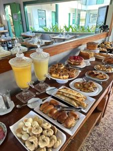 a buffet of pastries and drinks on a table at Pousada Solar dos Guaras in Catas Altas