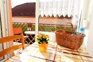 einen Tisch mit einem Korb und Blumen auf dem Balkon in der Unterkunft Apartman Molnár in Bük