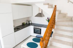 kuchnia z białymi szafkami i schodami w obiekcie V&V Amadores Apartment w mieście Puerto Rico de Gran Canaria
