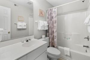 a white bathroom with a sink and a toilet at Golf Side Elegance 2BR Villa Hideaway in Pawleys Island