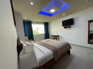 a bedroom with a bed with a blue ceiling at Fortune Hotel in Guayaquil