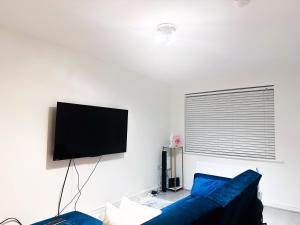 a living room with a blue couch and a flat screen tv at Luxury Room 8min to Sheffield City Center, Free parking in Manor +8 photos