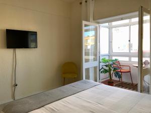 a bedroom with a bed and a television on the wall at Apartamento a 400 metros da praia Santa Cruz in Santa Cruz