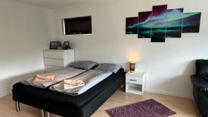 een kleine slaapkamer met een bed en een bank bij Ingi's Guesthouse with a Car in Miðvágur