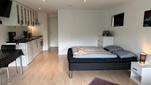 een kleine slaapkamer met een bed en een keuken bij Ingi's Guesthouse with a Car in Miðvágur +46 foto's