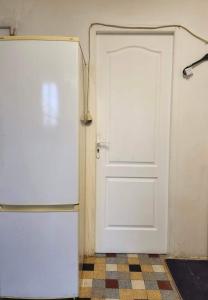 Una puerta blanca en una habitación junto a una nevera en Just for sleep - Hoche APT, en Le Pré-Saint-Gervais