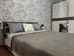 een slaapkamer met een groot bed en een spiegel bij 2х комнатная квартира в Центре города in Semey