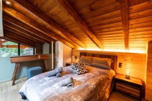 a large bed in a room with a wooden ceiling at Monte Verde Resort Kalavrita in Kalavrita