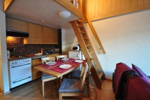 eine kleine Küche mit einem Holztisch und einer Treppe in der Unterkunft Studio Gamma in Zermatt