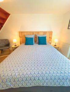 a bedroom with a large bed with blue pillows at Triplex à Plailly Parc Asterix CDG Villepinte in Plailly +13 photos