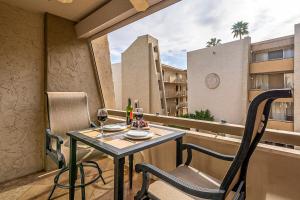 a table with two glasses of wine on a balcony at Modern Condo - Get to Old Town in Minutes! in Scottsdale
