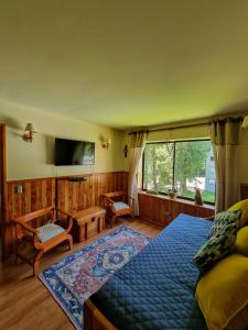 a bedroom with a bed and a large window at Departamento en Pucón - Camino al Volcan in Pucón