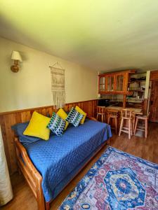 a bedroom with a bed with blue sheets and yellow pillows at Departamento en Pucón - Camino al Volcan in Pucón +18 photos