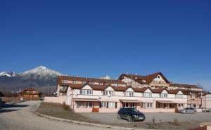 a large building with a car parked in front of it at Apartment Adriana 10E, Vysoké Tatry, High Tatras in Veľký Slavkov