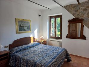 sypialnia z łóżkiem z niebieskim kocem i oknem w obiekcie Agriturismo La Bulletta w mieście Perugia