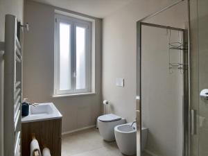 San Martino Suite - Pavia City - by HOST4U في بافيا: حمام مع حوض ومرحاض ونافذة