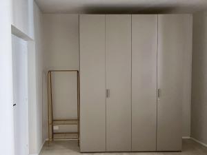 San Martino Suite - Pavia City - by HOST4U في بافيا: غرفة بها دواليب بيضاء ومرآة