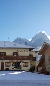 een gebouw met een berg op de achtergrond bij La Casa del Mulino in Pozza di Fassa