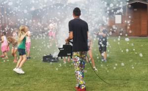 Ein Mann mit einem Schlauch vor einer Gruppe von Menschen. in der Unterkunft Osada nad Dziwną domki nad morzem in Dziwnów