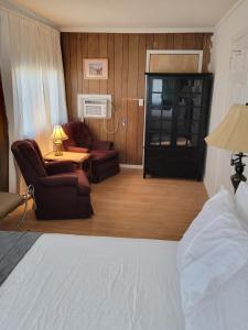a hotel room with a bed and chairs and a table at The Link Vintage Motel #1 2bd1ba in Lovelock