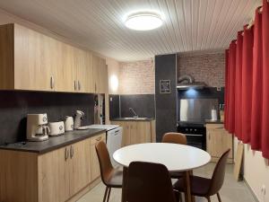 a kitchen with a table and a table and chairs at Maison bel-étage à Wavre in Wavre