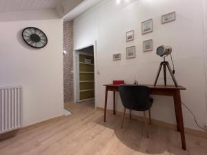 a room with a desk and a clock on the wall at Maison bel-étage à Wavre in Wavre