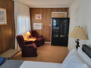a hotel room with a bed and two chairs at The Link Vintage Motel #1 2bd1ba in Lovelock
