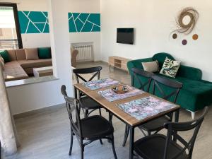a living room with a table and chairs and a couch at Azur vue sur mer au coeur de la marsa plage in La Marsa