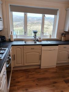 a kitchen with a sink and a window at Tigh a' Chreagain in Stockinish Island