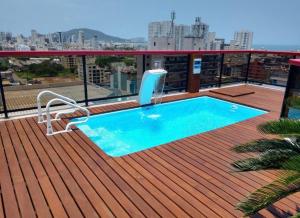 a swimming pool on the deck of a building at Triplex Guarujá in Guarujá