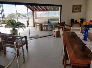 a dining room with a wooden table and chairs at Triplex Guarujá in Guarujá
