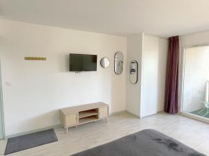 ルルドにあるStudio near train station and sanctuaryの白い壁のリビングルーム(テレビ付)