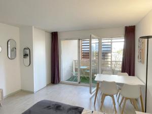 ルルドにあるStudio near train station and sanctuaryのテーブルと椅子と窓のあるダイニングルーム +3枚の写真