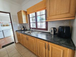 a kitchen with wooden cabinets and a sink and a window at Casa Su eño in Playa Blanca