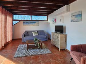 a living room with a couch and a tv at Casa Su eño in Playa Blanca