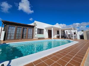 a villa with a swimming pool in front of a house at Casa Su eño in Playa Blanca