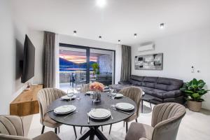 a living room with a table and chairs and a couch at Seafront Villa Kupinica with heated Pool in Vinišće